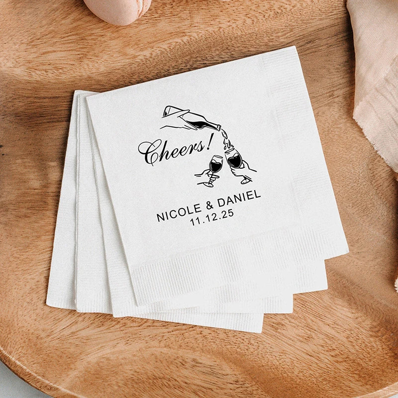 Custom monogram cocktail napkins personalized with names and wedding date, shown on wedding reception bar display.