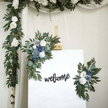 Artificial silk floral swag pair in champagne rose, shown on rustic wedding welcome sign backdrop.