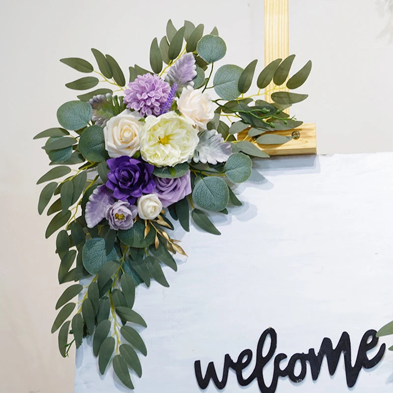 Artificial silk floral swag pair in champagne rose, shown on rustic wedding welcome sign backdrop.