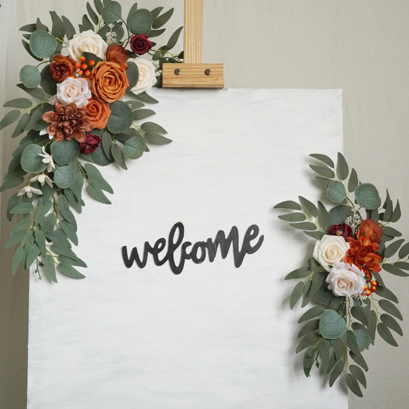 Artificial silk floral swag pair in champagne rose, shown on rustic wedding welcome sign backdrop.