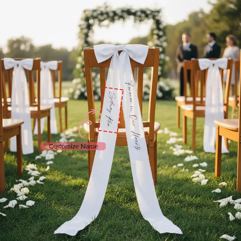 Personalized white memorial chair ribbon with 'Forever In Our Hearts' printed lettering, shown on reserved wedding ceremony chair.