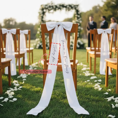 Personalized white memorial chair ribbon with 'Forever In Our Hearts' printed lettering, shown on reserved wedding ceremony chair.