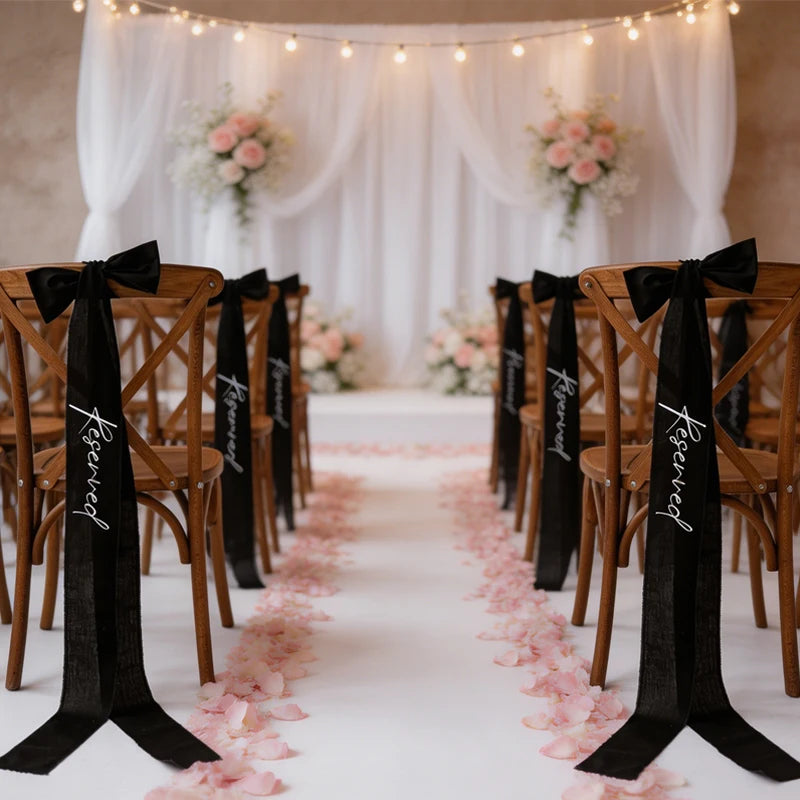 Elegant black 'Reserved' wedding chair seating ribbon, shown on ceremony chair display.