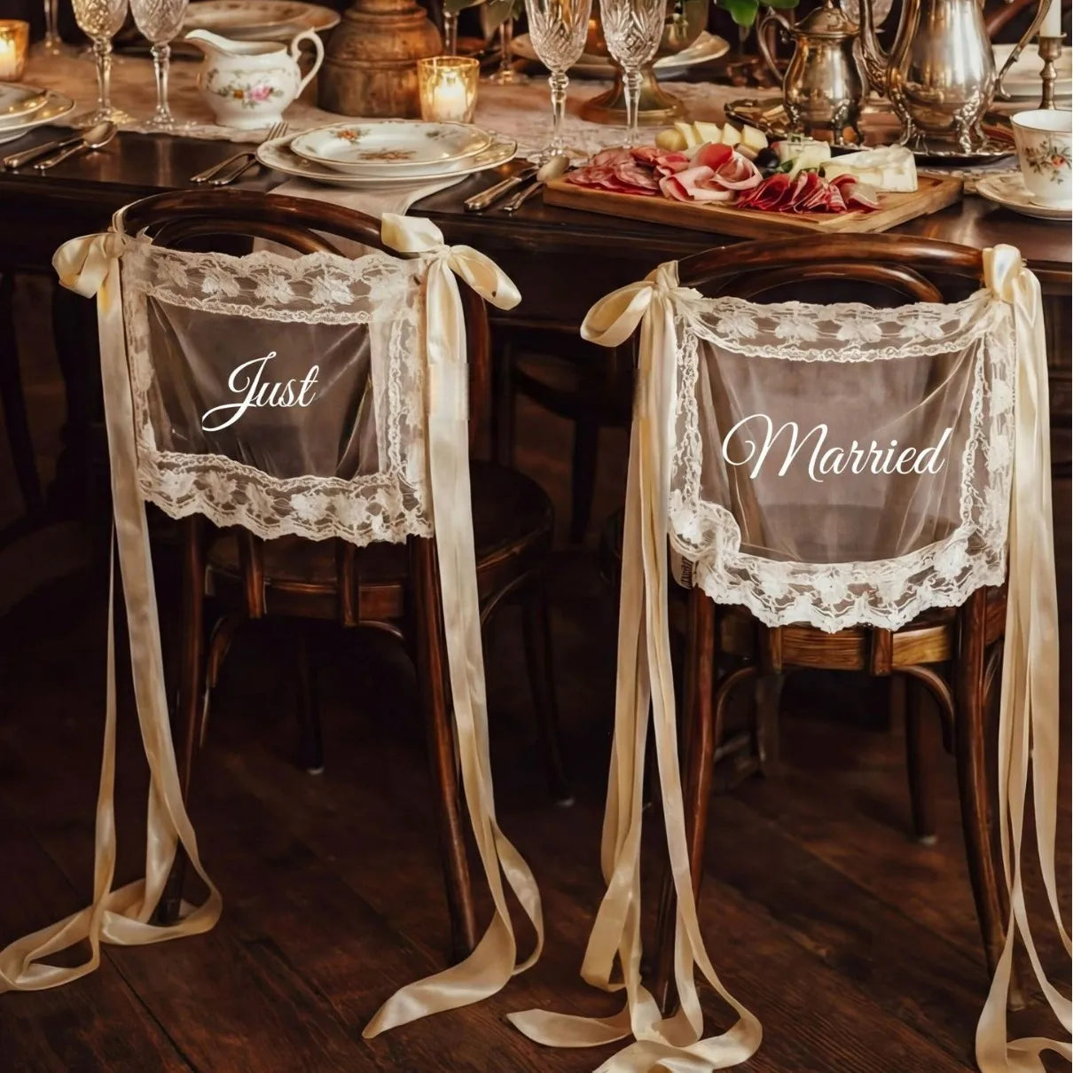 Sheer lace 'Just Married' chair sign set with 'Bride' and 'Groom' lettering, shown on wedding sweetheart table chair display.