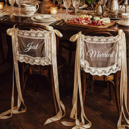 Sheer lace 'Just Married' chair sign set with 'Bride' and 'Groom' lettering, shown on wedding sweetheart table chair display.