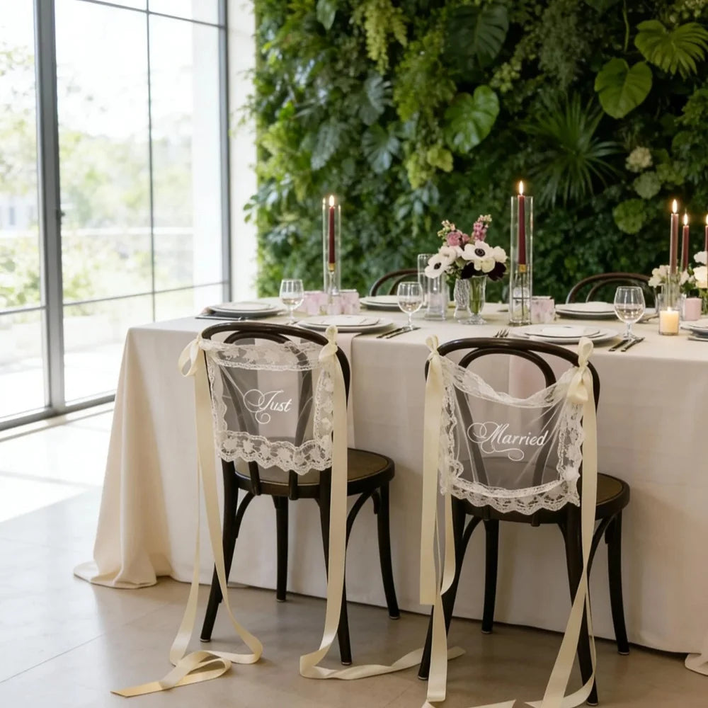 Sheer lace 'Just Married' chair sign set with 'Bride' and 'Groom' lettering, shown on wedding sweetheart table chair display.