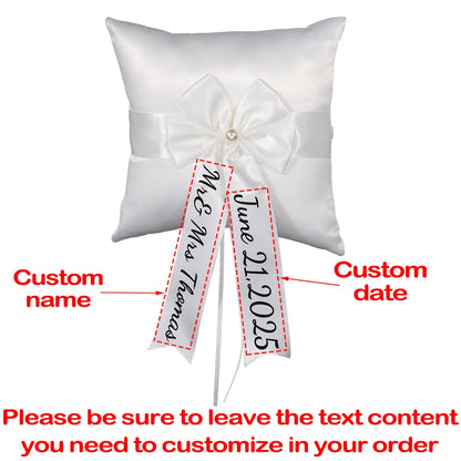 Personalized white flower girl basket and ring bearer pillow set with custom lettering, shown on wedding ceremony display.