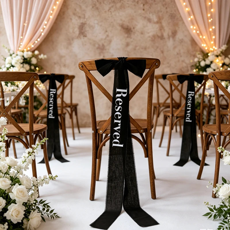 Elegant black 'Reserved' wedding chair seating ribbon, shown on ceremony chair display.