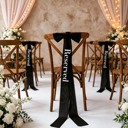 Elegant black 'Reserved' wedding chair seating ribbon, shown on ceremony chair display.