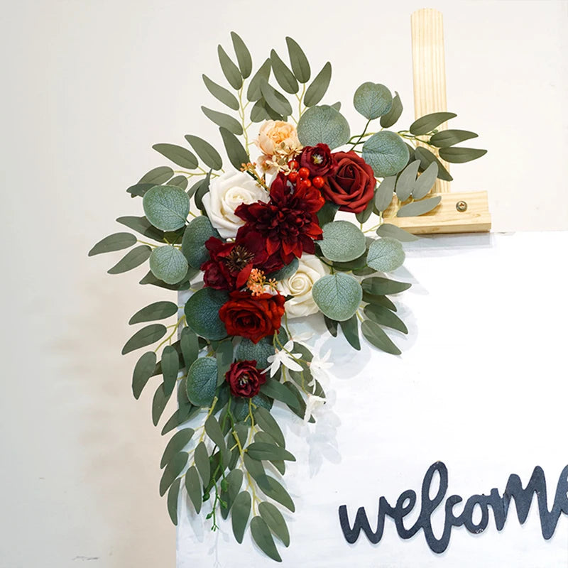 Artificial silk floral swag pair in champagne rose, shown on rustic wedding welcome sign backdrop.