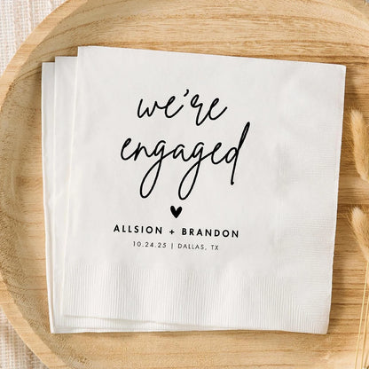 Custom monogram cocktail napkins personalized with names and wedding date, shown on wedding reception bar display.