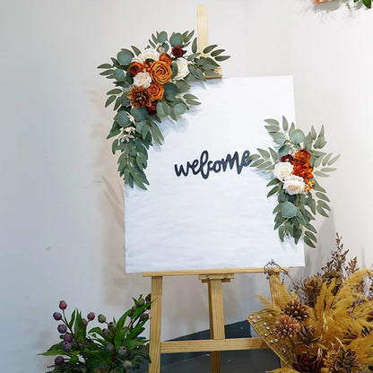 Artificial silk floral swag pair in champagne rose, shown on rustic wedding welcome sign backdrop.