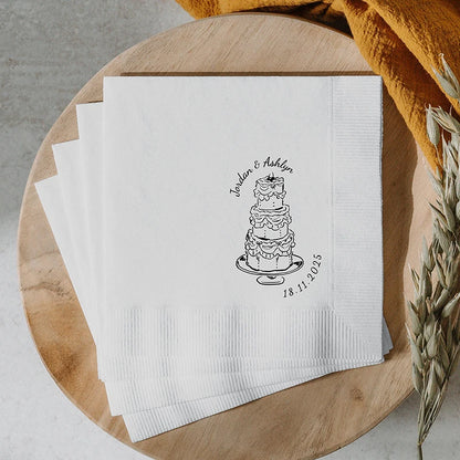 Custom monogram cocktail napkins personalized with names and wedding date, shown on wedding reception bar display.