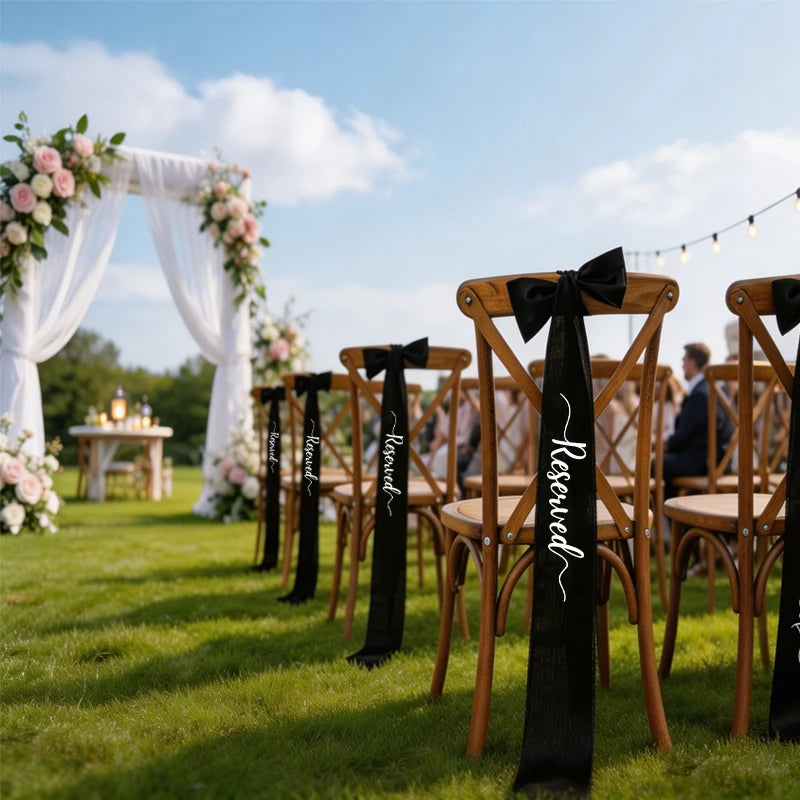 Elegant black 'Reserved' wedding chair seating ribbon, shown on ceremony chair display.