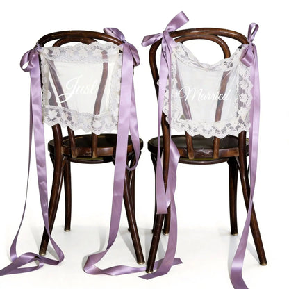 Sheer lace 'Just Married' chair sign set with 'Bride' and 'Groom' lettering, shown on wedding sweetheart table chair display.