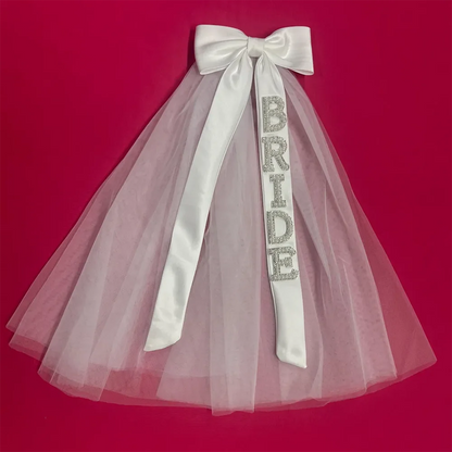 Bride to be pearl curvy veil in white tulle with satin bow, shown on bachelorette headpiece display.