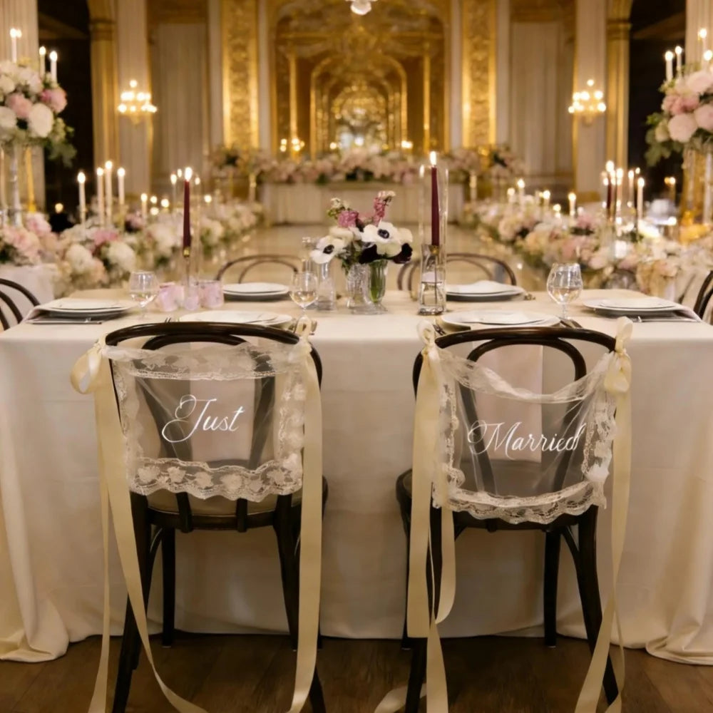 Sheer lace 'Just Married' chair sign set with 'Bride' and 'Groom' lettering, shown on wedding sweetheart table chair display.