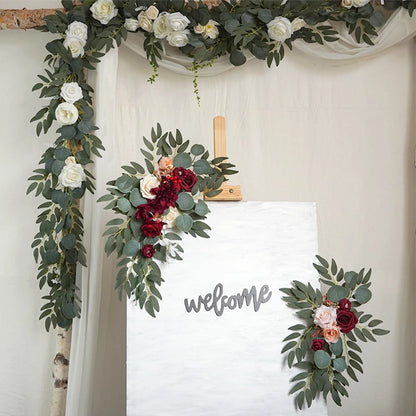 Artificial silk floral swag pair in champagne rose, shown on rustic wedding welcome sign backdrop.