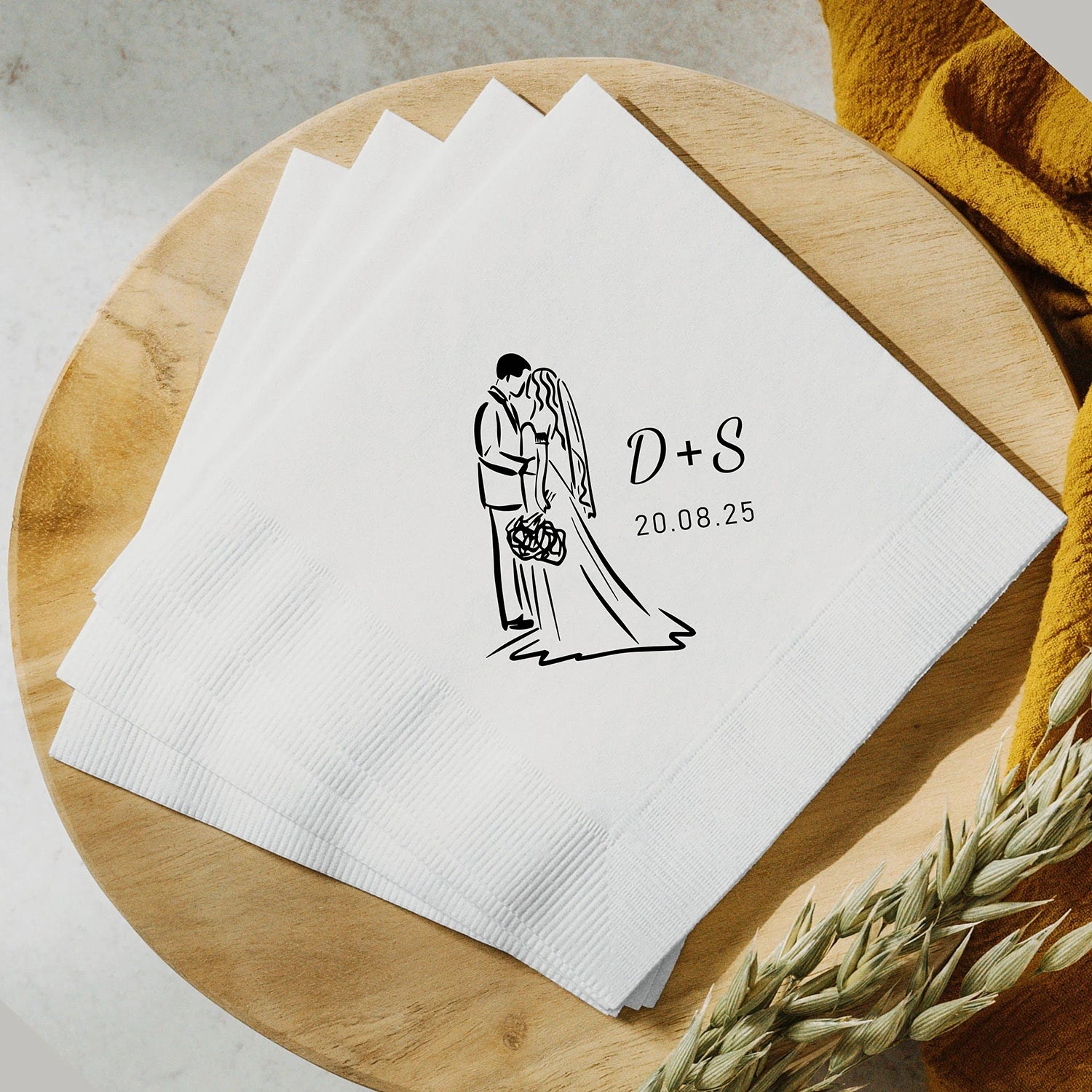 Custom monogram cocktail napkins personalized with names and wedding date, shown on wedding reception bar display.